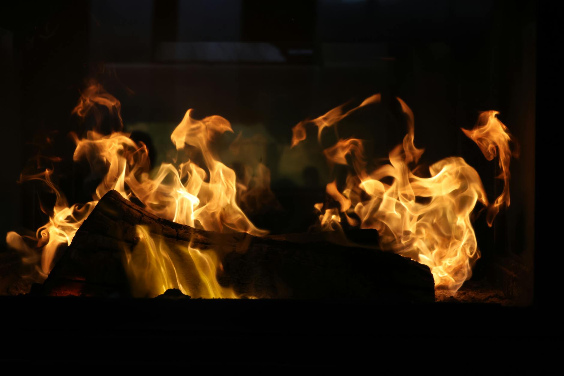 Captivating image of vibrant flames dancing in a rustic fireplace, creating a warm ambiance.
